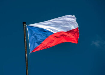 Czech national flag flies over the historic buildings on the Vltava River in Prague Czech Republic Czechia