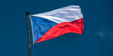 Czech national flag flies over the historic buildings on the Vltava River in Prague Czech Republic Czechia