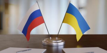 Ukrainian and russian flags on table. Negotiation between Russia and Ukraine. 3D rendered illustration.