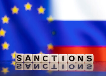 FILE PHOTO: Plastic letters arranged to read "Sanctions" are placed in front of EU and Russia's flag colors in this illustration taken February 25, 2022. REUTERS/Dado Ruvic/Illustration