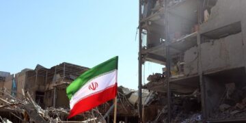 TEHRAN (IRAN(Islamic Republic Of)), 03/03/2026.- Iranian national flag placed next to a damaged building around Ferdowsi Square after an airstrike in central Tehran, Iran, 03 March 2026. A joint Israeli and US military operation continues to target multiple locations across Iran since the early hours of 28 February 2026. (Teherán) EFE/EPA/ABEDIN TAHERKENAREH